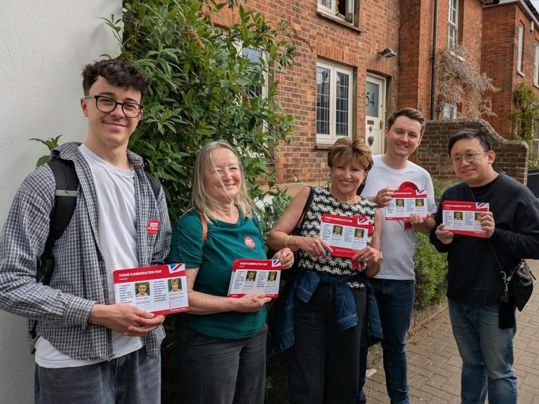 an image of Labour Party activists smiling holding up Labour Party leaflets